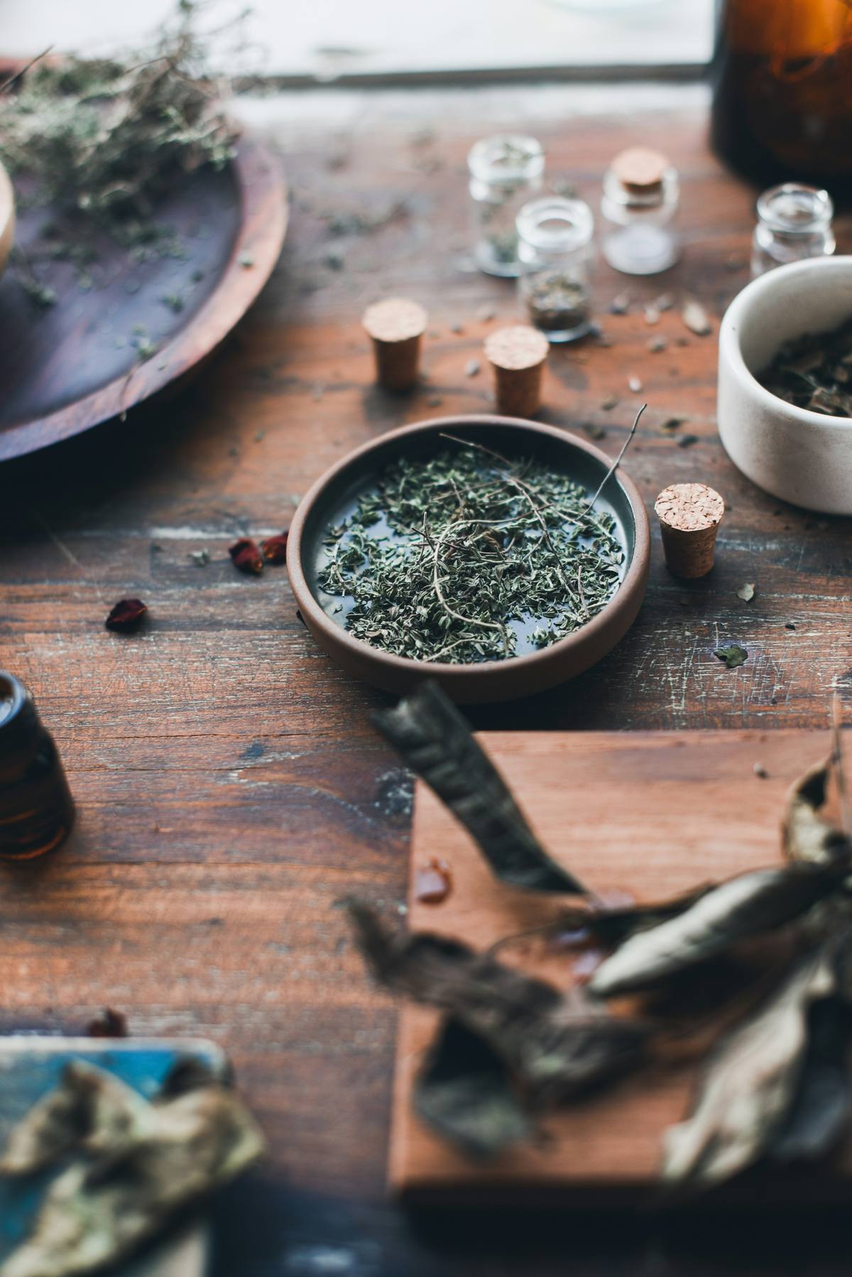 Dried herbs and calendula arranged on a ceramic plate on a wooden table